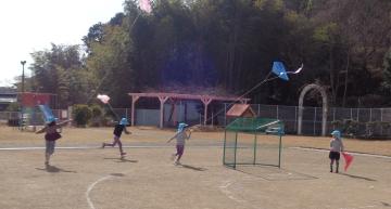 園庭で凧あげする園児たちの様子