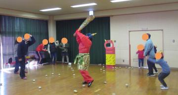 室内で鬼が金棒を振り回している様子