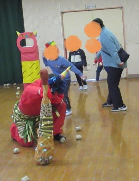 室内で子ども達の投げる豆で弱っている鬼の様子