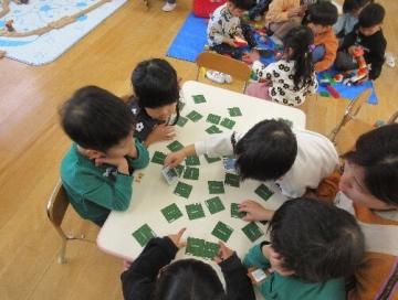 室内で3歳児がカード遊びをしているところ
