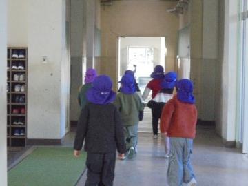 5歳児5人が小学校の廊下を歩いている様子