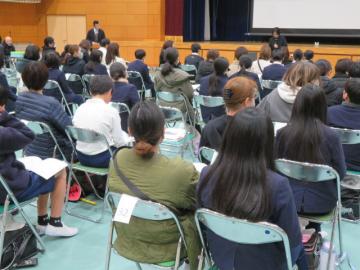 体育館で鹿谷中学校の校長先生のあいさつを聞く6年生の様子