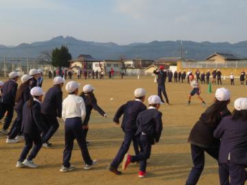 赤帽のサメ役につかまらないように逃げる子どもたち