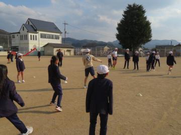 運動場で屋外スポーツクラブの運動を体験する3年生