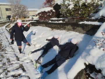 雪の斜面に人型をつけて遊ぶ4年生