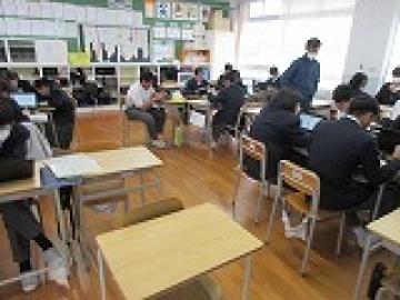 教室でグループを作って机を固めて話し合いをする生徒たち