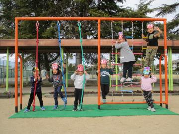 鬼のお面を付けて、遊具で集合写真を撮ったようす