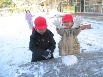 雪をまるめて遊んでいるこどもたちの様子