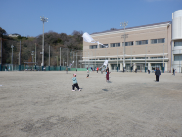 園庭で凧あげをしている園児たちの様子