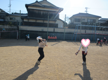 園庭で羽根つきで遊んでいる園児たちの様子