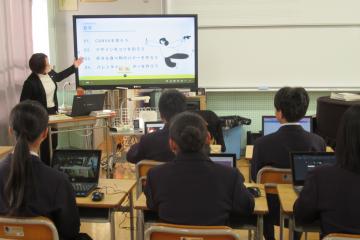 7年生が音楽室で講師の説明を聞いている様子