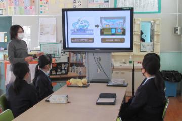 7年生が図書室で講師の説明を聞いている様子