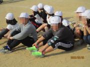 運動場にお山座りをして固まっている児童たちが応援するようす1