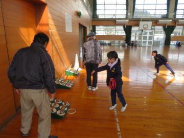 体育館で長寿会の皆さんにわなげを教えてもらう1年生の児童たちの様子