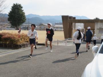 坂道ダッシュをする6年生児童たちとその横を通る別の児童たちの様子