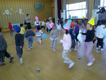 教室で、鬼のお面をかぶった子供に向かって豆を投げている子供の様子2