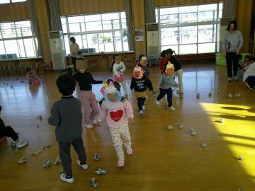 教室で、鬼のお面をかぶった子供に向かって豆を投げている子供の様子3