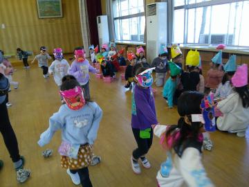 教室で、鬼のお面をかぶった子供に向かって豆を投げている子供の様子1