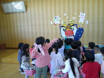 大きな鬼の口に豆を投げ入れている様子