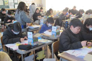 教室の自席で、5年生が理科の実験器具を準備している様子