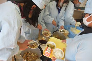 前期課程、給食当番が給食をよそっている様子