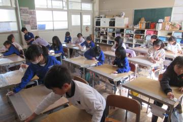 2年生が各自の机をシートで拭いている様子