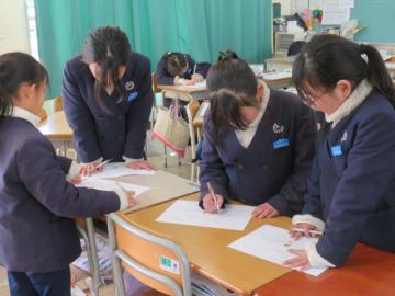 教室でワークシートを交換して意見交流する4年生の様子