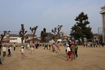 校庭で子どもたちが鬼ごっこをしている写真