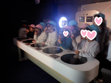 館内の暗所で光の遊びを体験している園児たちの様子