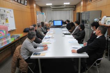 会議室で教師たちがテーブルをはさんで座り、会議をしている様子