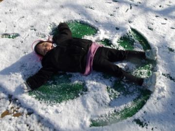 幼児が雪の上で寝転ぶ姿