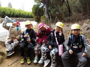 幼児が森の中で休憩する様子