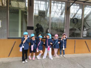 姫路セントラルパークの園内でチンパンジーと記念撮影する園児たちの様子