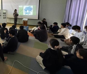 6年生の児童がプロジェクターを使って発表をしている様子