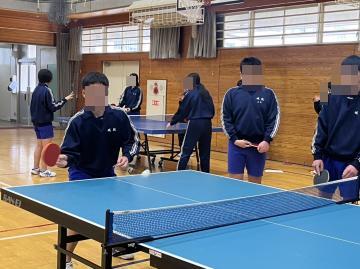 男子生徒が卓球をしていて、相手のサーブを打ち返しています。