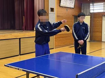 男子生徒が相手のサーブを打ち返しています。