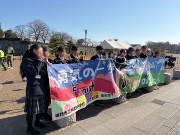 生徒たちが横断幕を持ってマラソン選手を応援する様子