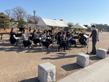 外の椅子に座って生徒が応援演奏する様子