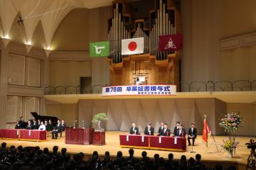 卒業式の様子。来賓が会場の壇上で着席している様子