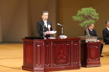 会場の壇上で学校長が式辞を述べる様子