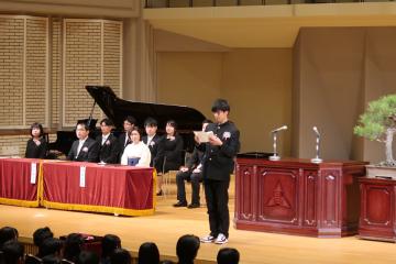 会場の壇上で卒業生代表者が答辞を述べる様子