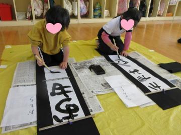 室内で書初めする5歳児たちの様子