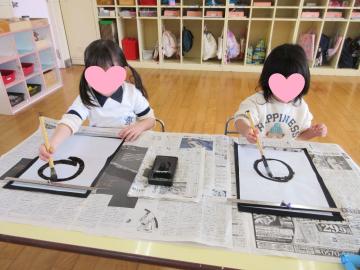 室内で書初めする4歳児たちの様子