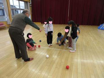 講師の指導を受け、遊戯室でボッチャをしている園児たちの様子