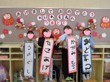 書いた書初めで集合写真を撮る5歳児たちの様子