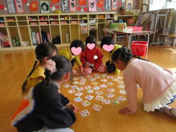 室内で全員でカルタ取りをしている園児たちの様子
