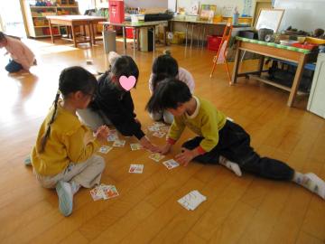室内で5歳児の園児たちがカルタ取りをしている様子