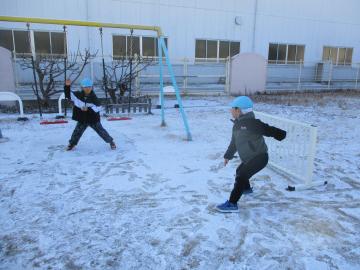 雪を投げ合って遊ぶ子供