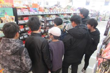 スーパーの店内で児童がお菓子売り場の前で思案している様子