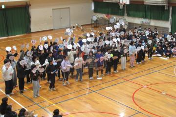 体育館で5年生の児童たちがうちわパフォーマンスを披露している様子